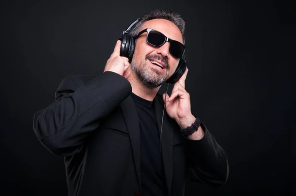 Elegante hombre guapo escuchando música — Foto de Stock