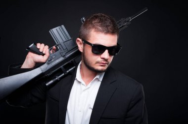 Bir ateşli silah tutan yakışıklı genç