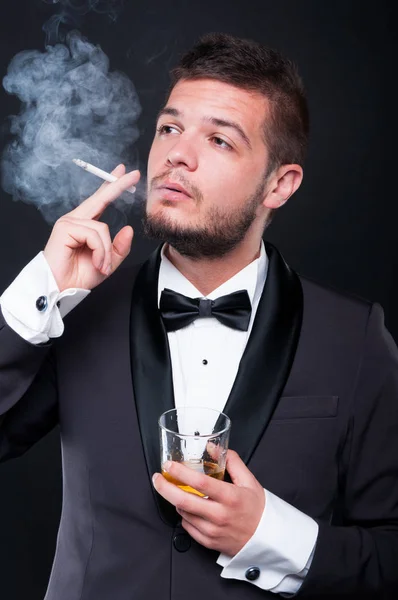 Fiatal exkluzív pasas, szivar dohányzás és a whiskyt ivott — Stock Fotó