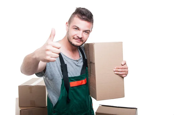 Mover guy holding cardboard box showing thumb up — Stock Photo, Image