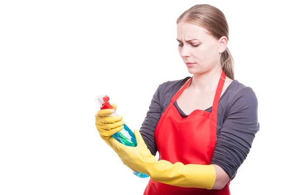 Mulher bonita lendo o rótulo de spray de limpeza — Fotografia de Stock