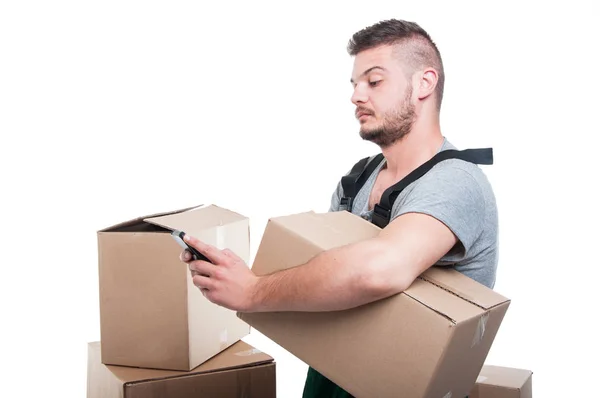 Mover homem segurando caixa de papelão e mensagens de texto smartphone — Fotografia de Stock