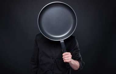 Yüzünü önünde tutan tava yemek