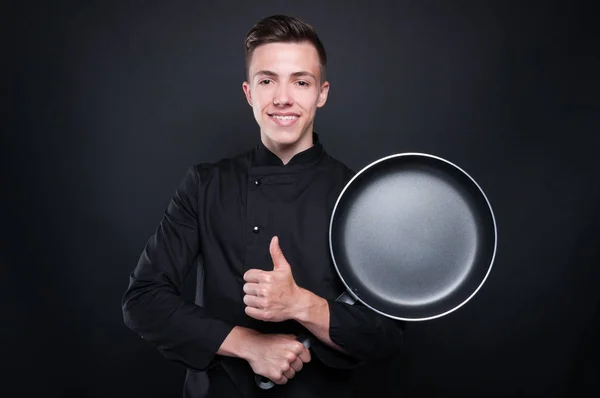 Jovem chef de uniforme com frigideira — Fotografia de Stock