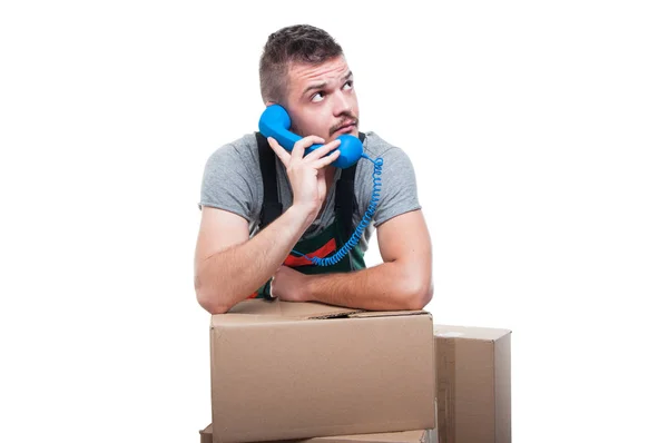 Mover man talking at phone with boxes around — Stock Photo, Image