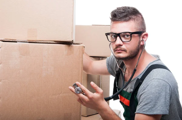 Mover guy posing holding cardboard box with stethoscope — Stock Photo, Image