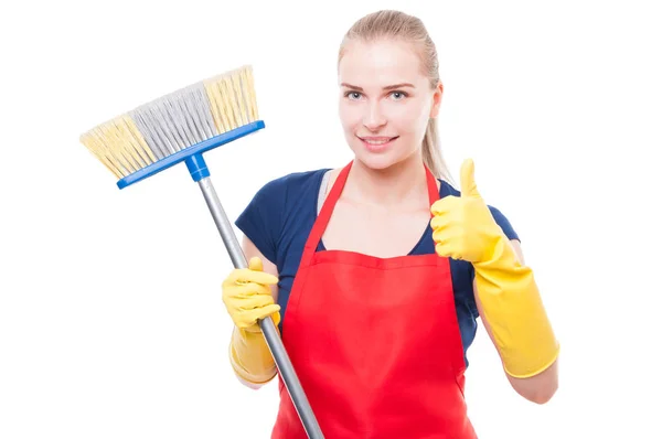 Mujer atractiva sosteniendo escoba y sonriendo a la cámara — Foto de Stock