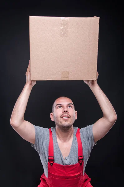 Mover man holding up one cardboard box — Stock Photo, Image