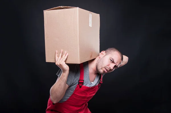 Mover man carrying heavy cardboard box — Stock Photo, Image