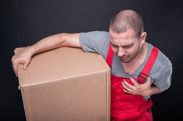 Mover man holding box heaving heart pain — Stock Photo, Image