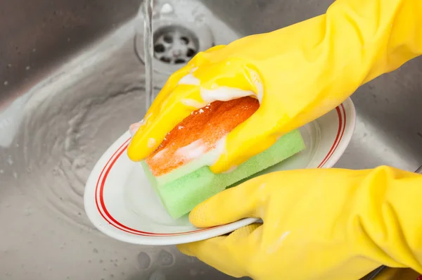 Limpeza senhora ou dona de casa com esponja prato de lavagem — Fotografia de Stock