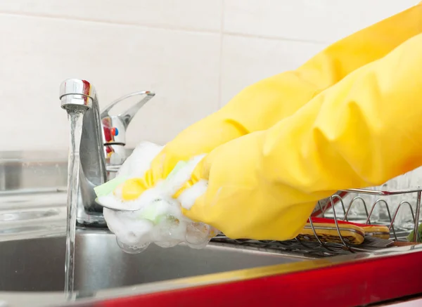 Ženské ruce mytí příborů v jímce — Stock fotografie