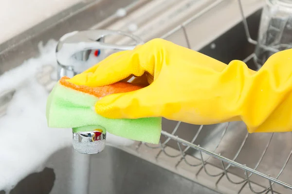 Mujer limpiando a mano el grifo del fregadero — Foto de Stock