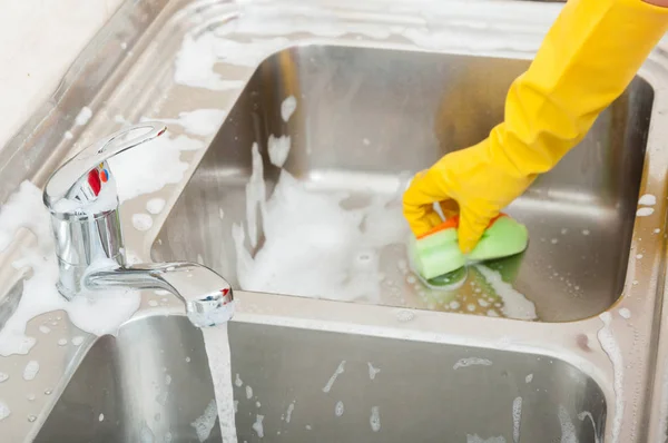 Persona que limpia el fregadero de la cocina con esponja —  Fotos de Stock