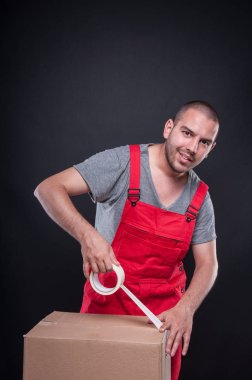 Koli bandı ile kutu ambalaj taşıyıcı adam