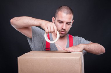 Koli bandı ile kutu ambalaj taşıyıcı adam