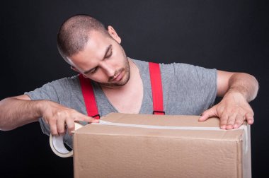 Taşıyıcı adam dikkatle ambalaj kutu koli bandı ile
