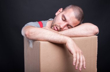 Yorgun ve bitkin taşıyıcı adam karton kutu uyku