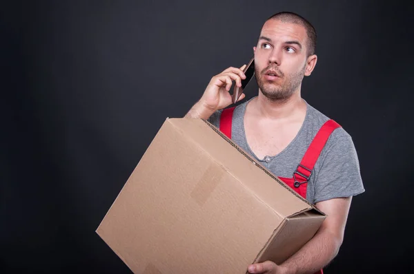 Чоловік тримає коробку, що розмовляє на мобільному телефоні — стокове фото