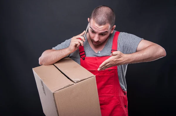 Рушійний чоловік тримає коробку, даючи пояснення про телефон — стокове фото