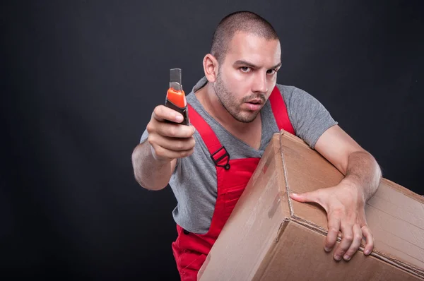 Mover hombre de la caja de sujeción y herramienta de corte en serio — Foto de Stock