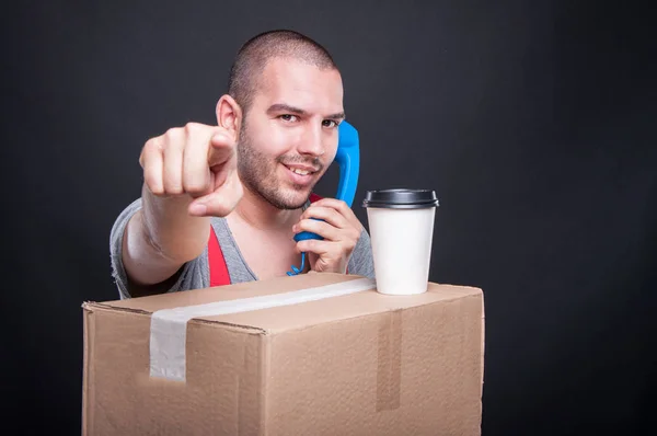 Mover guy talking on phone having coffee pointing camera — Stock Photo, Image