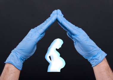 Hamile bir kadın silüeti korumak eller