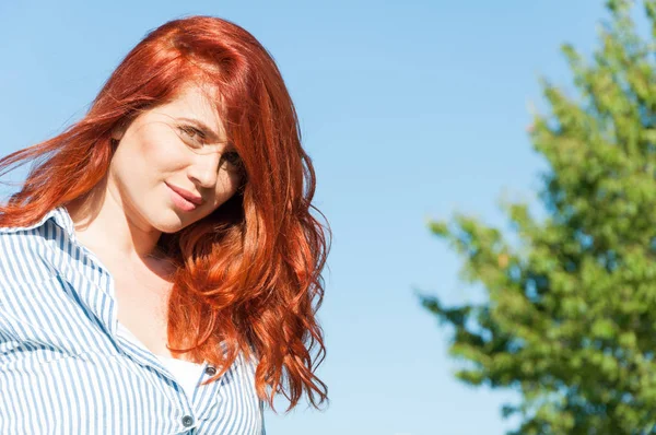 Rothaarige Frau lächelt glücklich an einem sonnigen Sommertag — Stockfoto