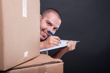 Taşıyıcı adam notlar alarak kutuları saklanıyor