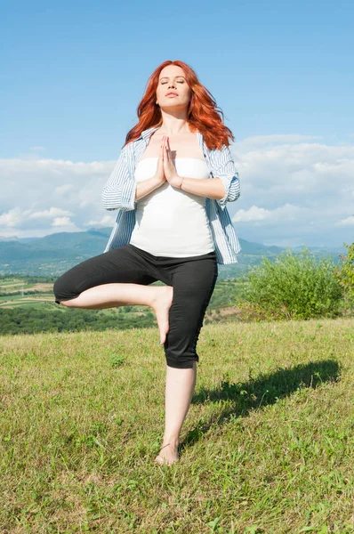 Jovem ruiva mulher está praticando ioga — Fotografia de Stock
