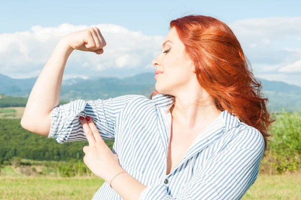 Jeune rousse femme montrant son bras fort — Photo