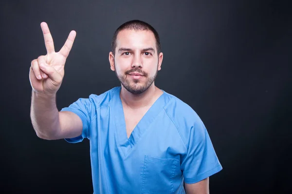 Portret męski pielęgniarka pokazuje gest pokoju — Zdjęcie stockowe