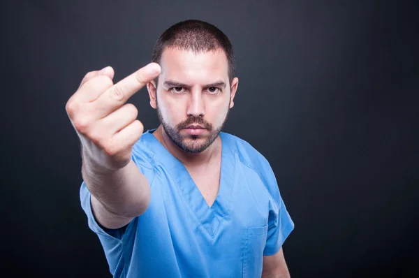 Manliga medicinsk sjuksköterska visar obscen gest — Stockfoto