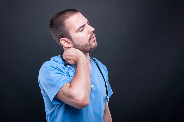 Porträtt av läkare som bär scrubs att ha tillbaka nacksmärta — Stockfoto