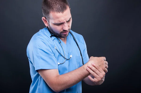 Retrato de médico vestindo esfrega com dor de pulso — Fotografia de Stock