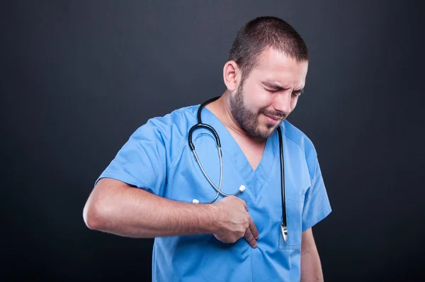 Doctor wearing scrubs having suffering stomach ache — Stock Photo, Image