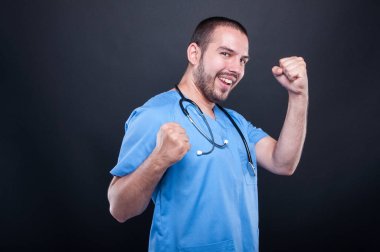 Mutlu başarı gest yapma stetoskop ile önlük giyen doktor