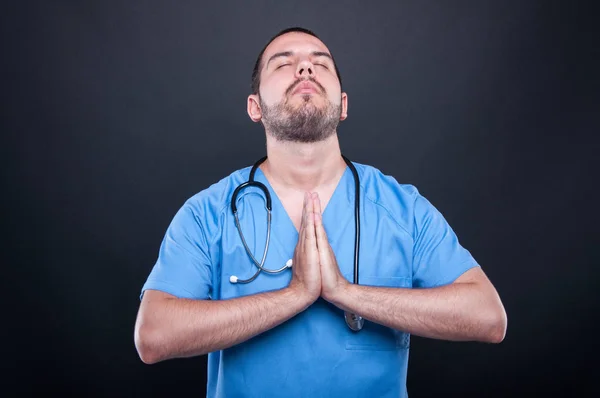 Médico usando esfoliação com estetoscópio orando — Fotografia de Stock