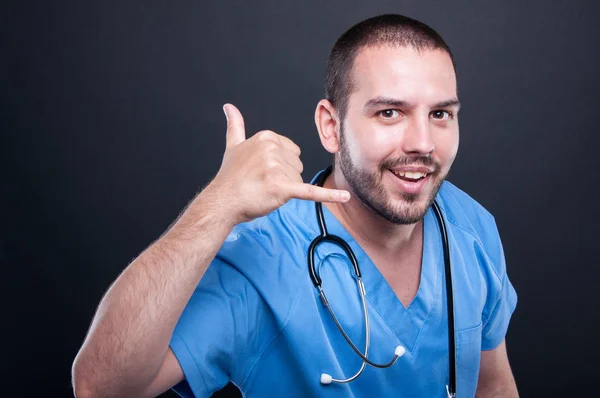 Läkare som bär scrubs med stetoskop gör anropande gest — Stockfoto