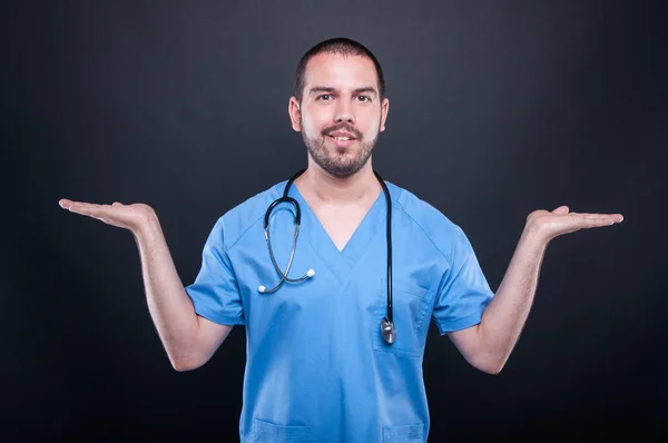 Läkare som bär skrubbar med stetoskop holding copypsace båda ha — Stockfoto