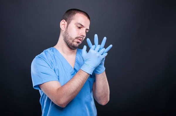 Doctor con exfoliantes arreglando sus guantes de látex —  Fotos de Stock