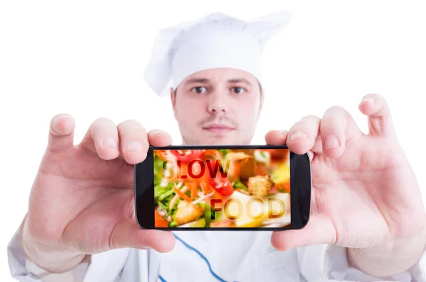 Повар показывает смартфон со здоровой пищей — стоковое фото