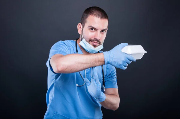 Doutor com estetoscópio mostrando tempo fora com sua lancheira — Fotografia de Stock