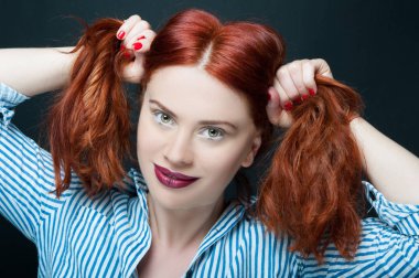 Çekici redhaired kadın onun ponytails tutar
