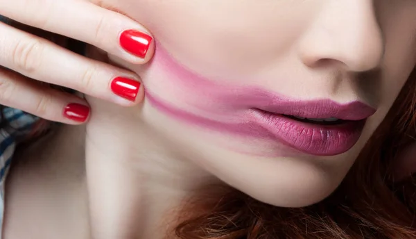 Vrouw gezicht met vlekkerig lippenstift in closeu — Stockfoto