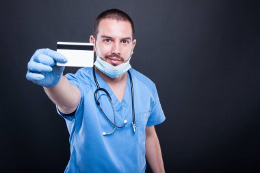 Doktor önlük ve maske gösteren kredi kartı