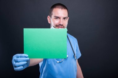Holding ve yeşil copypsace kartı gösteren doktor