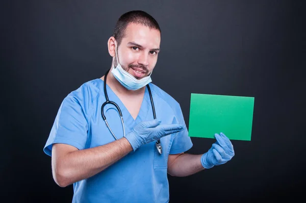 Dokter holding en groene copypsace kaart — Stockfoto