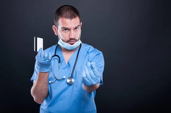 Doctor holding card making money gesture — Stock Photo, Image