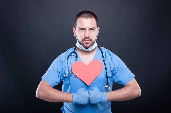 Kardiolog med rött hjärta form poserar stark — Stockfoto